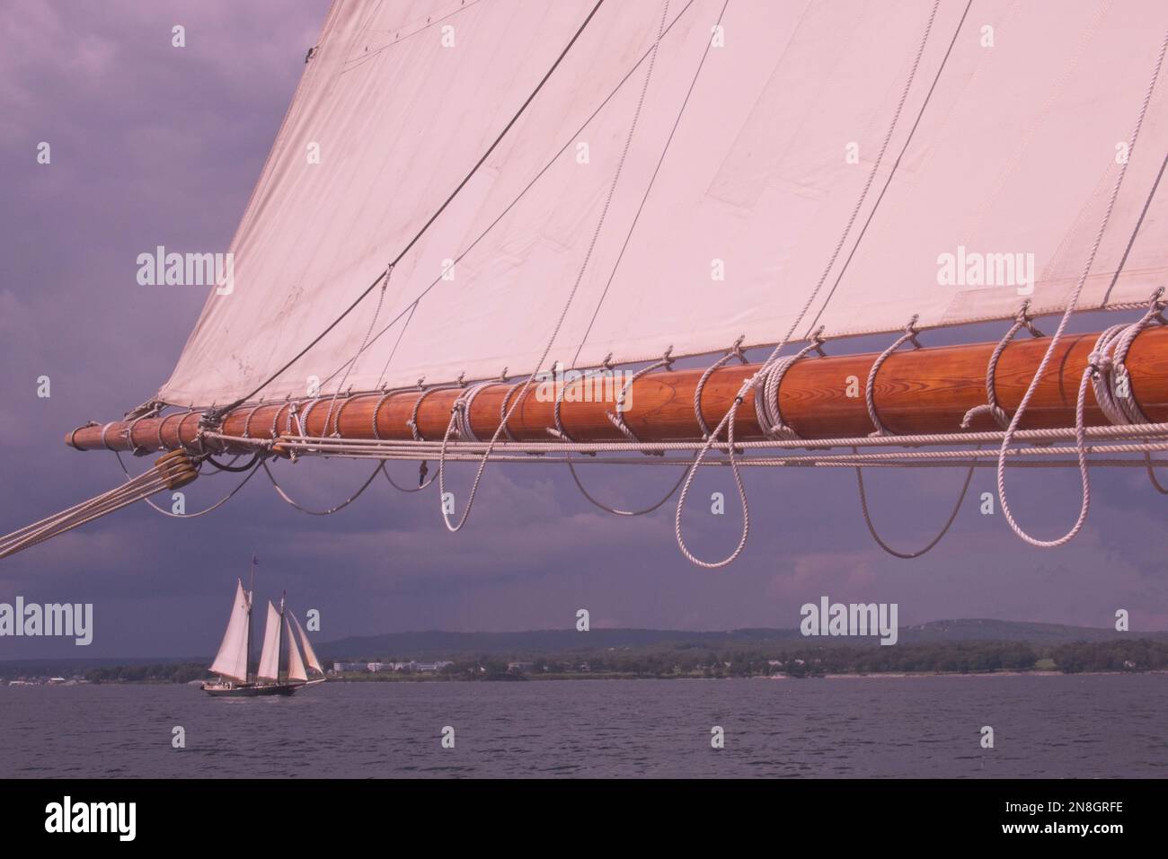 Ein klassisches Großschiff, das vor der Küste von Maine segelt, vom Deck eines anderen alten Großschiffs aus gesehen. Stockfoto