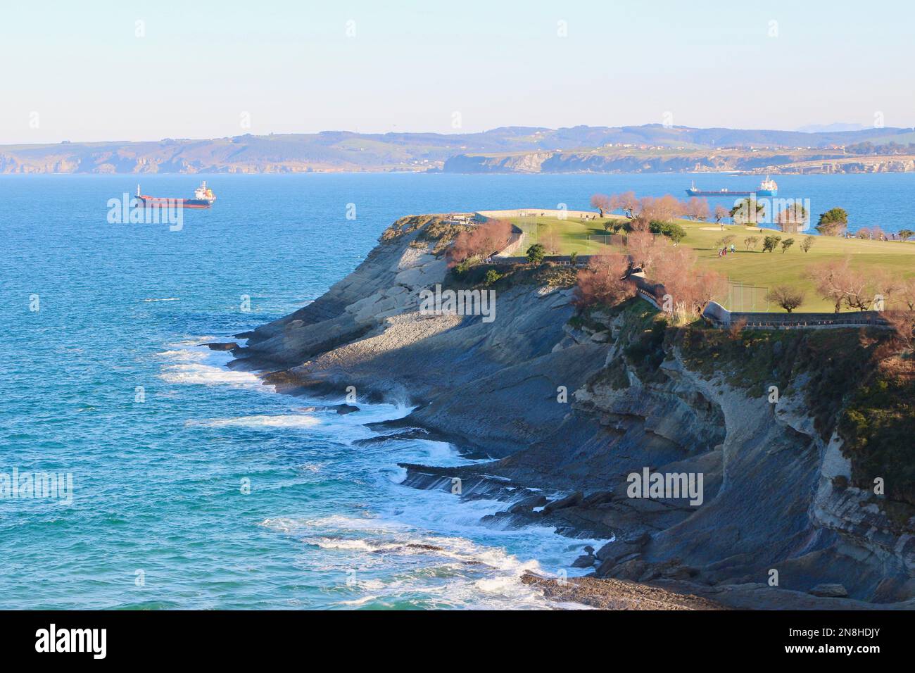 Landschaftsblick über den Matalenas Golfplatz mit verankerten Schiffen und die Insel Mouro und den Leuchtturm Santander Cantabria Spanien Stockfoto