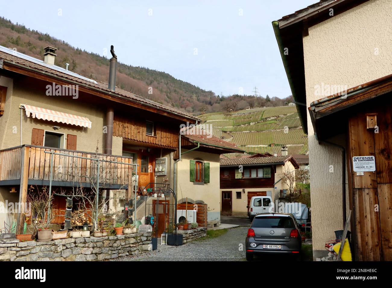 Alte Bauernhäuser mit Weinbergen im Hintergrund in Ollon, Schweiz Stockfoto