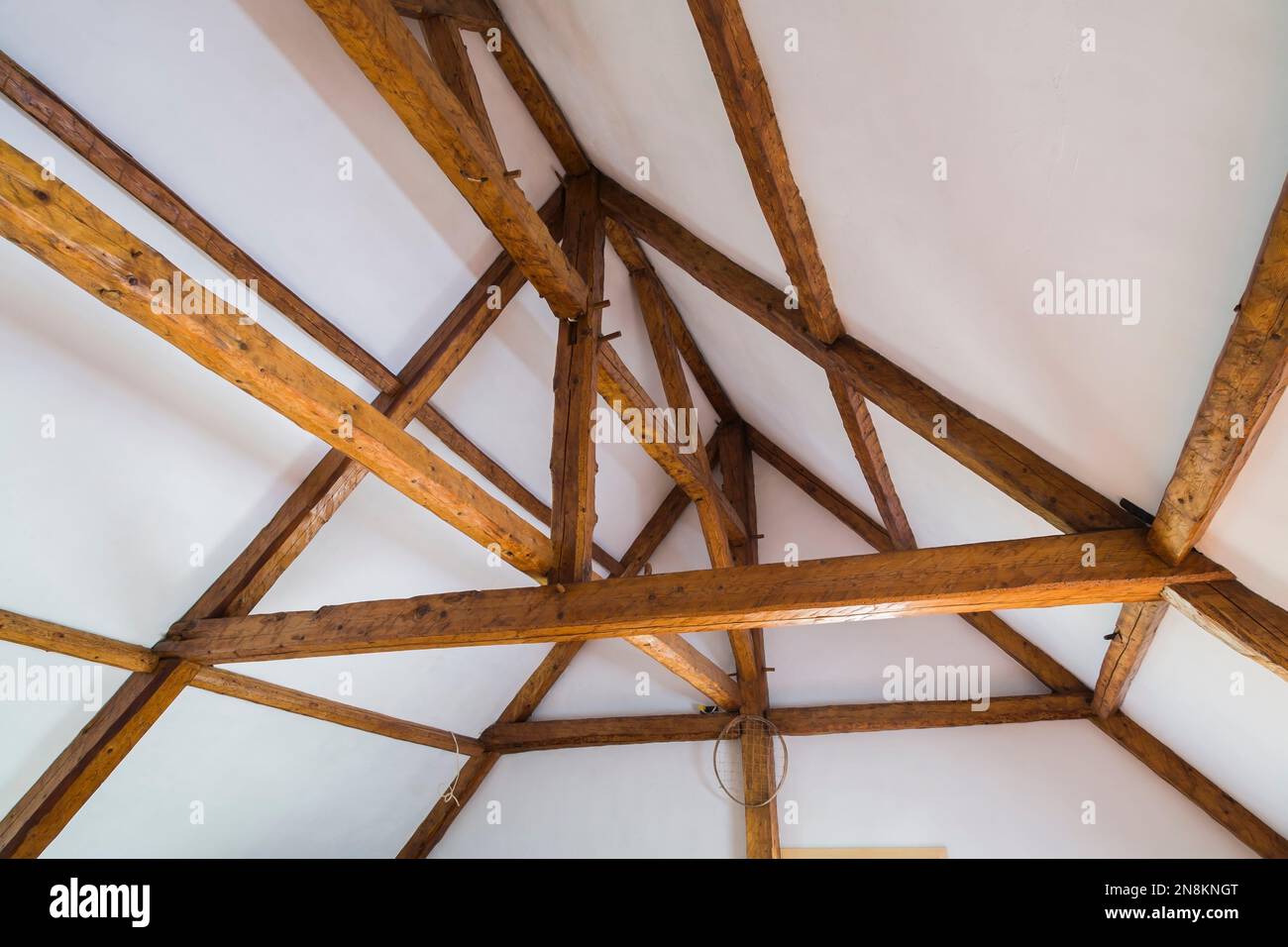 Weiße raue Decke und originales Holzgerüst mit Balken mit Mortis- und Sehnenfugen im Dachgeschoss im alten französischen Regimehaus aus den 1809 Jahren. Stockfoto