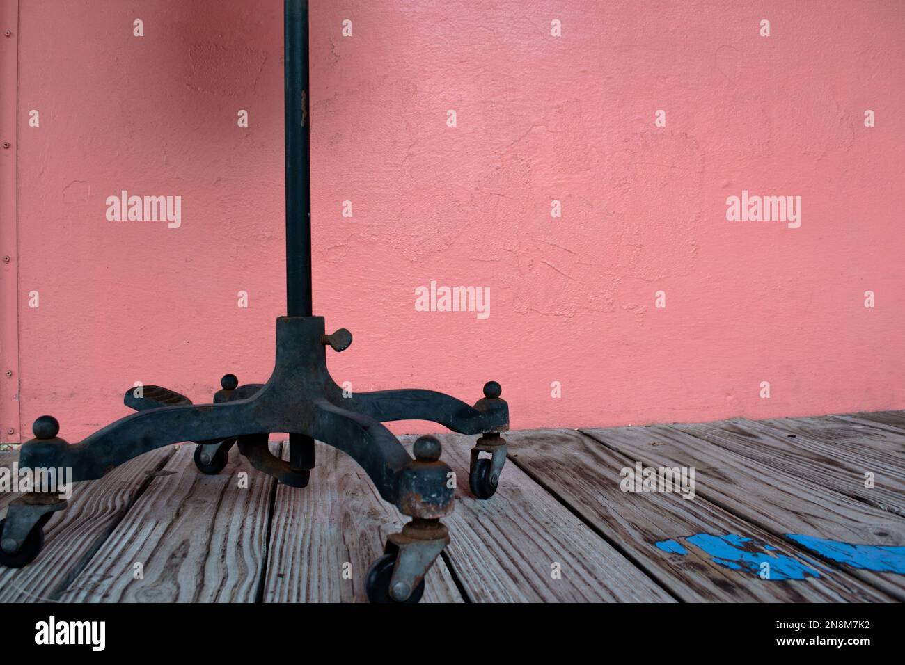 Antiker Ständer auf Holzboden mit rosafarbener Wand Stockfoto