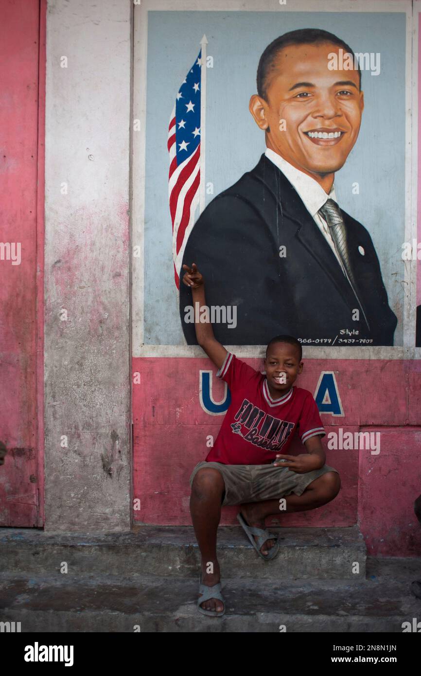 Resident Thony Jeff, 14, poses for pictures in front of an image depicting President Barack Obama in Petion-Ville, Haiti, Wednesday Nov. 7, 2012. Obama was re-elected for a second presidential term, defeating his Republican challenger, former Massachusetts Gov. Mitt Romney in Tuesday's election. (AP Photo/Dieu Nalio Chery) Stockfoto
