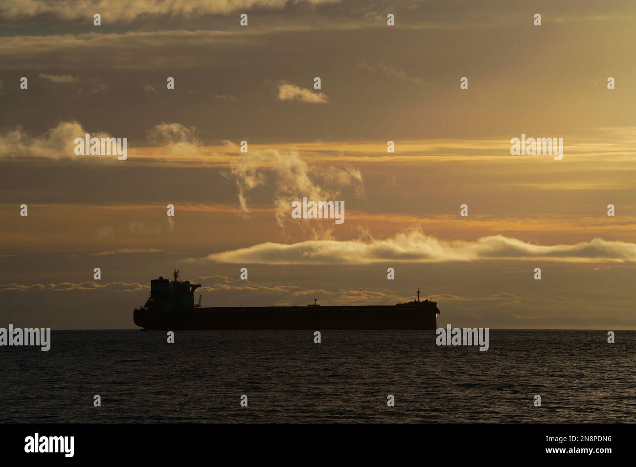 Handelsschiffe vor Anker, Sonnenaufgang. Stockfoto