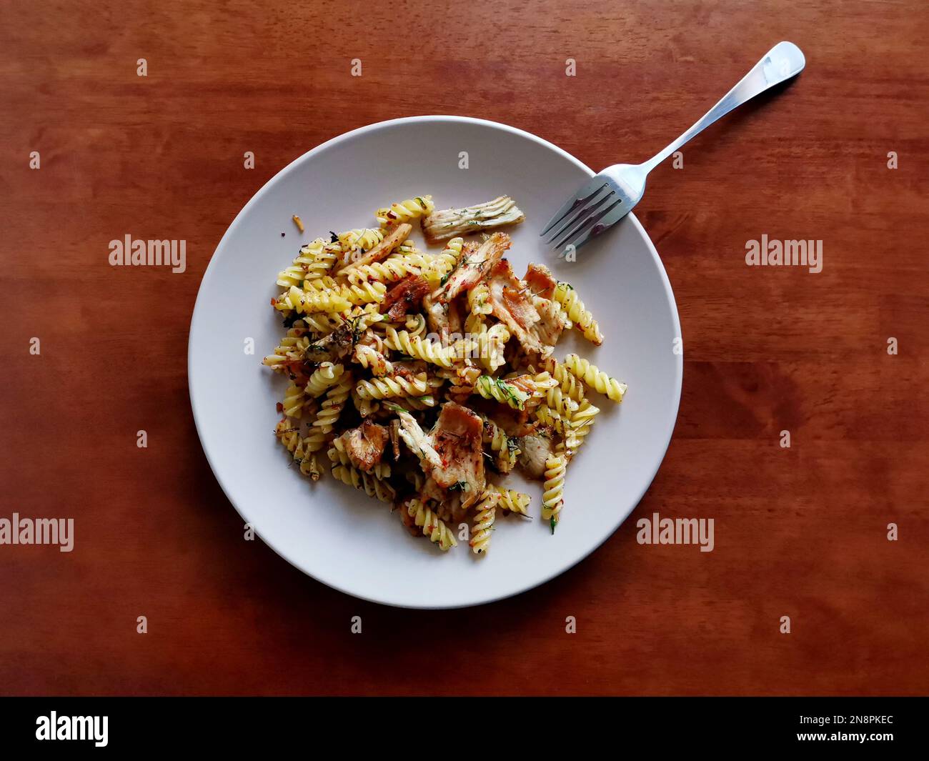 Fusilli-Pasta mit gebratenen Fleischscheiben, serviert mit Kräutern und Gewürzen Stockfoto