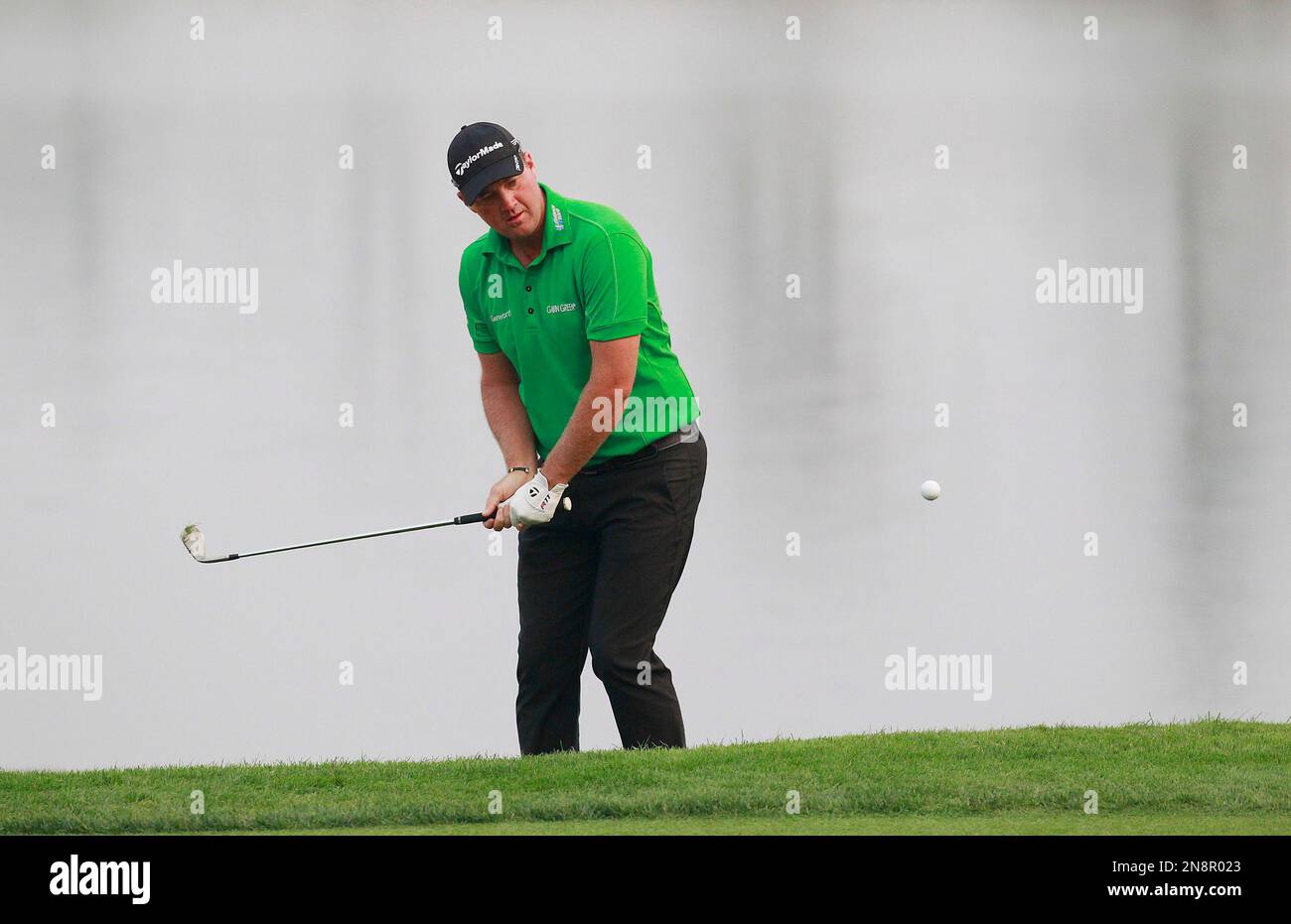 Peter Hanson from Sweden hits a shot from the rough of the 18th green during the Masters golf tournament in Shanghai, China on Sunday Oct. 28, 2012. (AP Photo/Eugene Hoshiko) Stockfoto