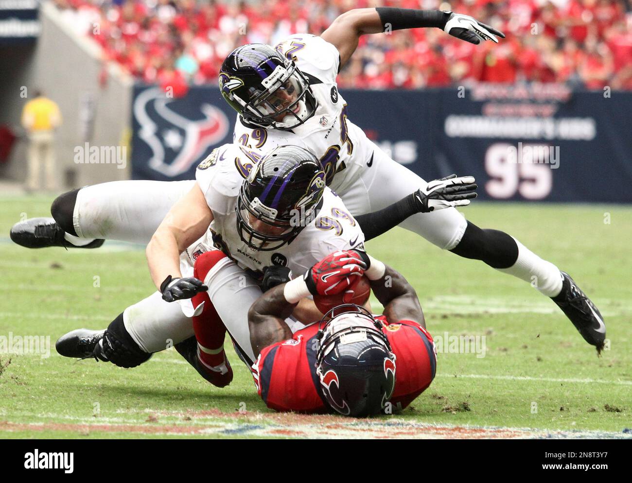 Baltimore Ravens Paul Kruger (99) and Cary Williams (29) pile on Houston Texans wide receiver Andre Johnson during the third quarter of an NFL football game, Sunday, Oct. 21, 2012, in Houston. (AP Photo/Patric Schneider) Stockfoto