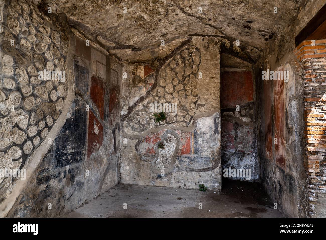 Freiliegendes Mauerwerk unter Fresken in den Ruinen von Pompeji, Italien Stockfoto