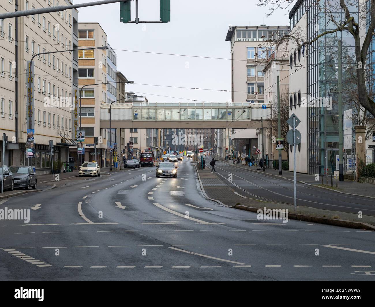Lange Strassenblick mit dem Brückensteckverbinder des Krankenhauses. Architektonisches Merkmal oberhalb der belebten Straße. Stadtleben in Frankfurt am Main. Stockfoto