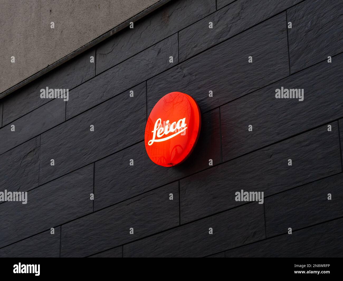 Leica-Kameralogo an einer dunklen Wand. Geschäft und Galerie mit Premium-Fotoausrüstung. Hochwertige Produkte für wohlhabende Menschen und Profis. Stockfoto