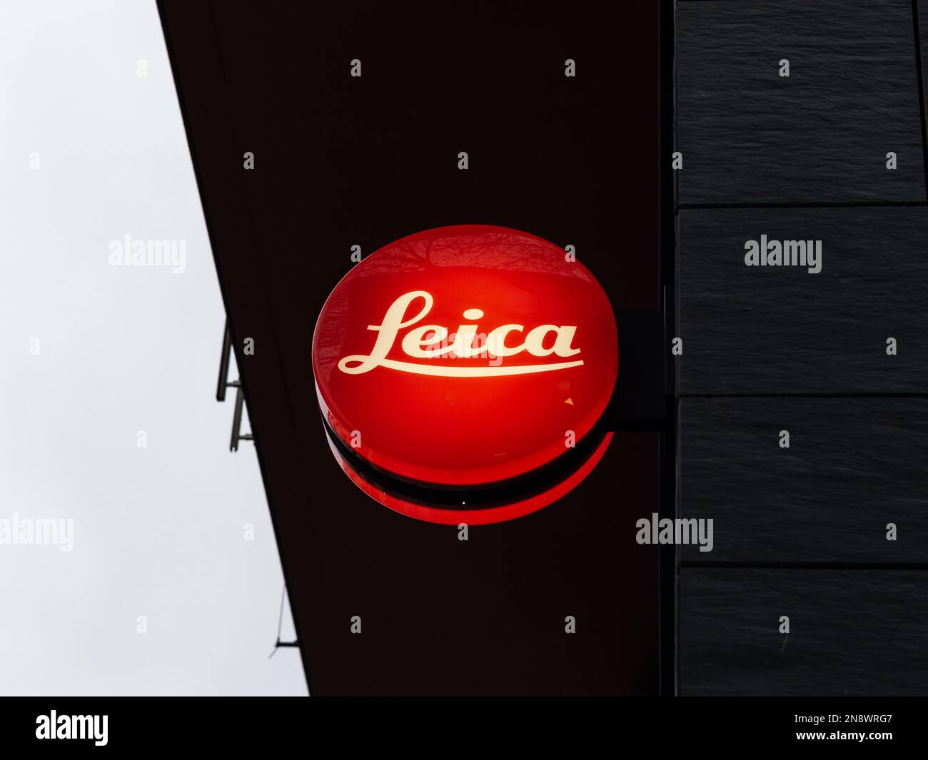 Leica-Kameralogo auf einem Ladengebäude in der Stadt. Beleuchtetes Schild des deutschen Herstellers. Hochpräzise Kamera- und Objektivsysteme. Stockfoto
