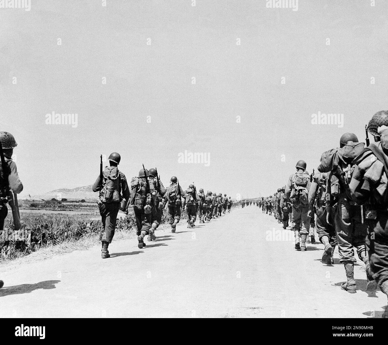 After successfully establishing beachheads in the invasion of Sicily, American troops file on both sides of a road toward the interior of the Italian island on July 24, 1943. (AP Photo) Stockfoto
