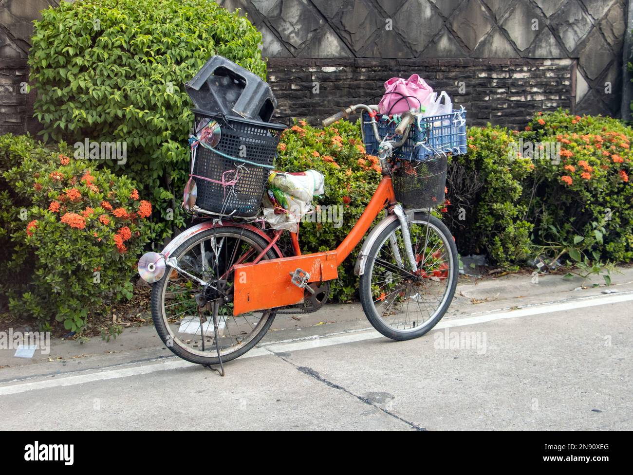 Ein Fahrrad mit Ladung parkt auf der Straßenseite, Thailand Stockfoto