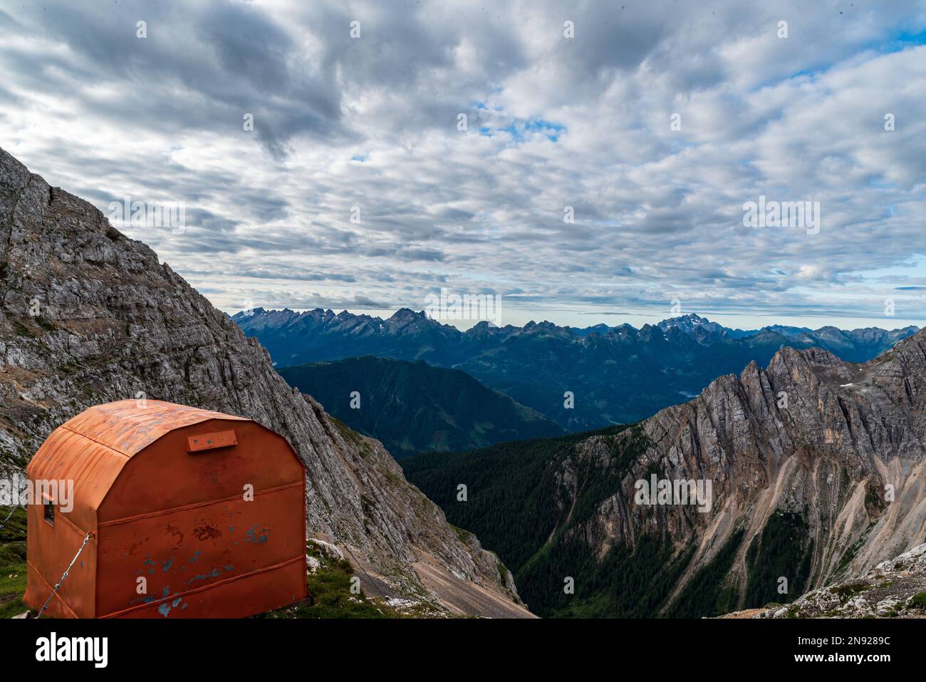 Bivacco Mario Rigatti auf Forcella Grande del Latemar auf der Berggruppe Latemar in den Dolomiten mit Gipfeln der Fiemme-Berge im Hintergrund Stockfoto