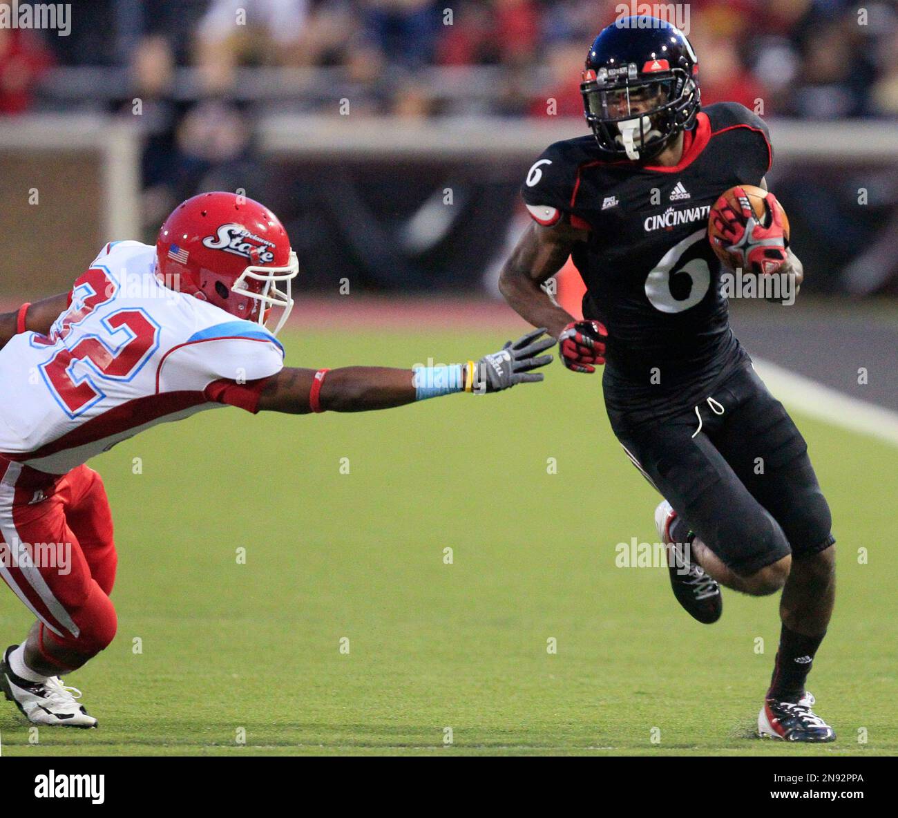 Cincinnati wide receiver Anthony McClung (6) avoids a tackle by Delaware State defensive back Cameren Judge in the first half of an NCAA college football game, Saturday, Sept. 15, 2012, in Cincinnati. (AP Photo/Al Behrman) Stockfoto