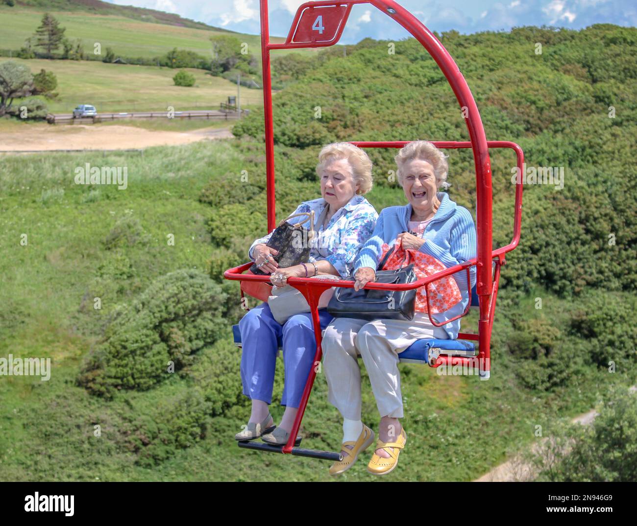 Glückliche alte Damen auf dem Sessellift in Needles Park, Isle of Wight Stockfoto