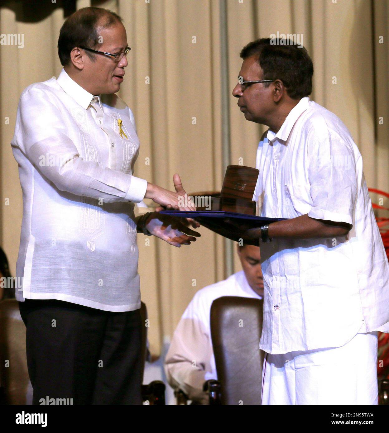 Philippine President Benigno Aquino III, left, presents a medallion to India's Kulandei Francis, one of the six Ramon Magsaysay awardees for this year, during ceremony Friday Aug. 31, 2012 in Manila, Philippines. The Ramon Magsaysay Awards is Asia's most prestigious awards and is the equivalent of the Nobel Prize.(AP Photo/Bullit Marquez) Stockfoto