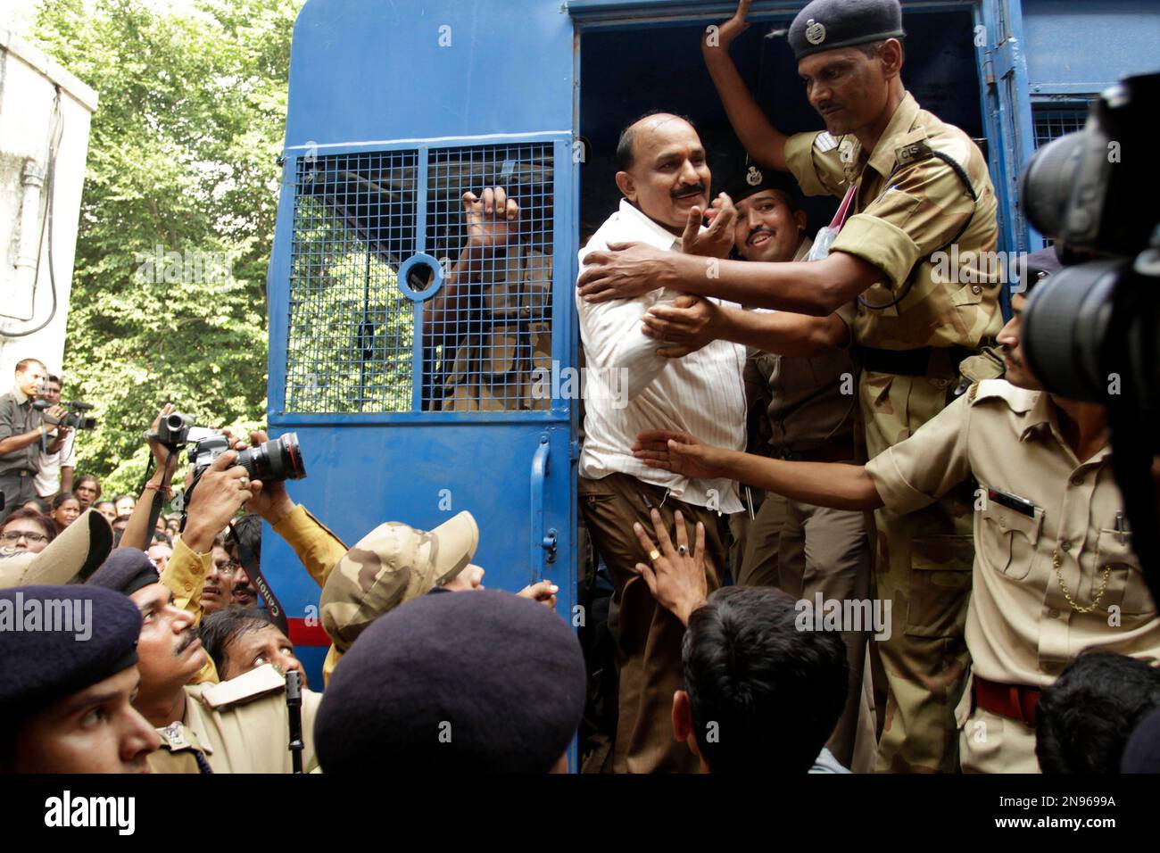 Former Bajrang Dal leader Babu Bajrangi is escorted in a police vehicle to be taken to prison