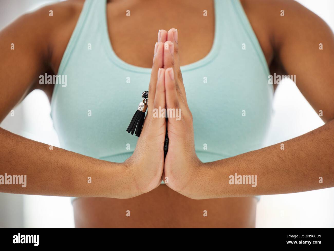 Arbeiten mit einer starken Denkweise. Eine unbekannte Frau, die mala-Perlen hält und in einem Yoga-Studio meditiert. Stockfoto