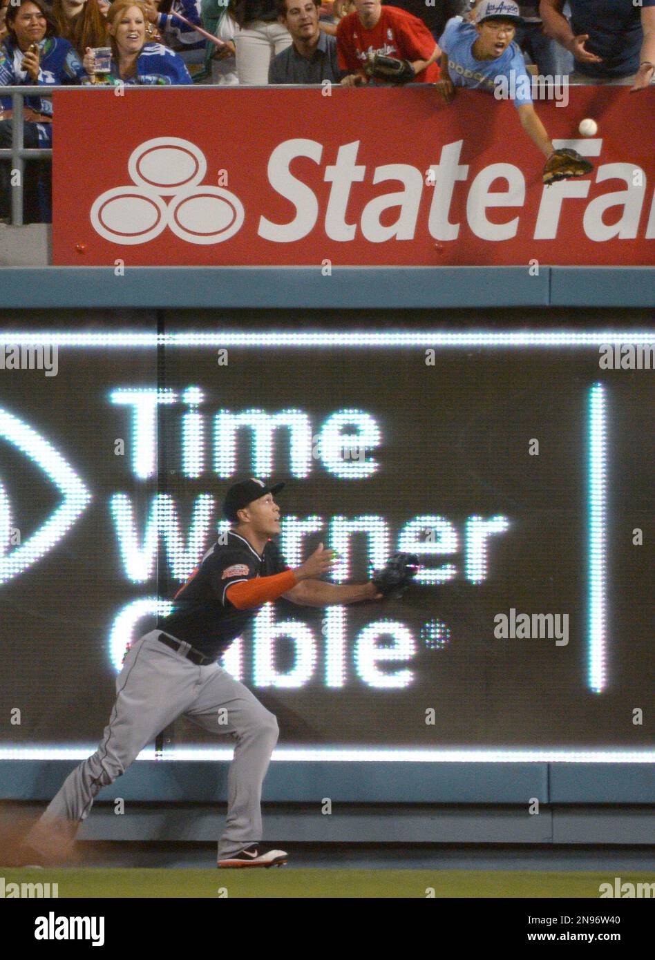 A young fan, upper right, tries to catch a ball hit by Los Angeles Dodgers' Hanley Ramirez for a two-run home run as Miami Marlins right fielder Giancarlo Stanton watches during the third inning of their baseball game, Friday, Aug. 24, 2012, in Los Angeles. (AP Photo/Mark J. Terrill) Stockfoto