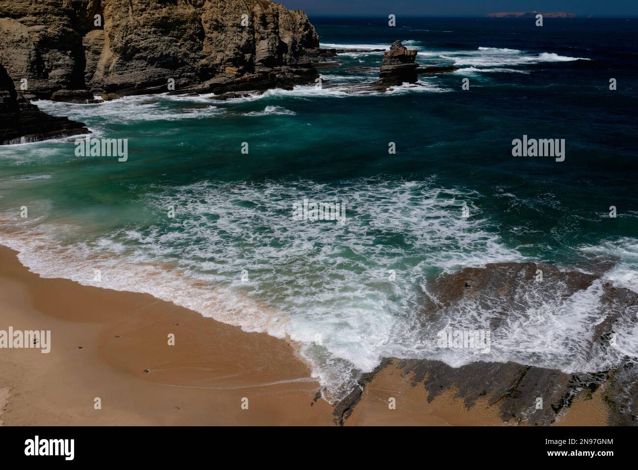 Eine Linie im Sand: Atlantikschaum treibt sich über einen Regalstrand und über ein flaches Regal aus Sedimentgestein aus dem frühen Jurassic an der zerklüfteten Küste von Cabo Carvoeiro in Peniche im Stadtteil Leiria im Zentrum Portugals. Direkt vor der Küste befindet sich Berlenga Grande, die größte der Berlenga-Inseln und ein Paradies für Meerestiere und Seevögel. Stockfoto