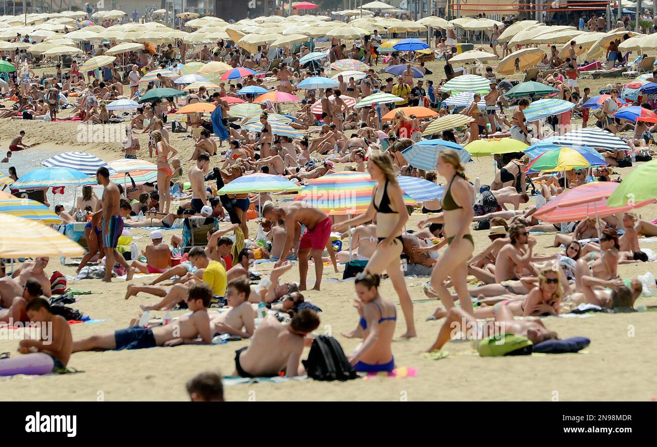 People enjoy the sun at Barceloneta Beach in Barcelona, Spain, Saturday, Aug. 11, 2012. Most of Spain is currently suffering from a heat wave with temperatures reaching around 40 degrees Celsius (104 degrees Fahrenheit). (AP Photo/Manu Fernandez) Stockfoto