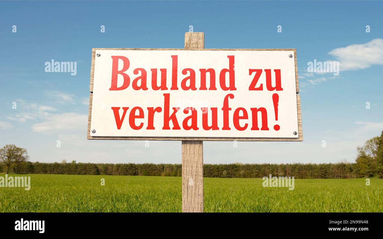 Greenfield-Schild: Bauland zum Verkauf! Unterschreiben Sie in einem grünen Feld mit dem deutschen Text: Stockfoto