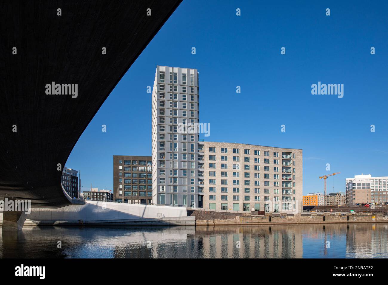 Blick aus dem niedrigen Winkel auf die Atlantinsilta-Brücke und neu gebaute Wohngebäude in Jätkäsaari oder im Bezirk Länsisatama in Helsinki, Finnland Stockfoto