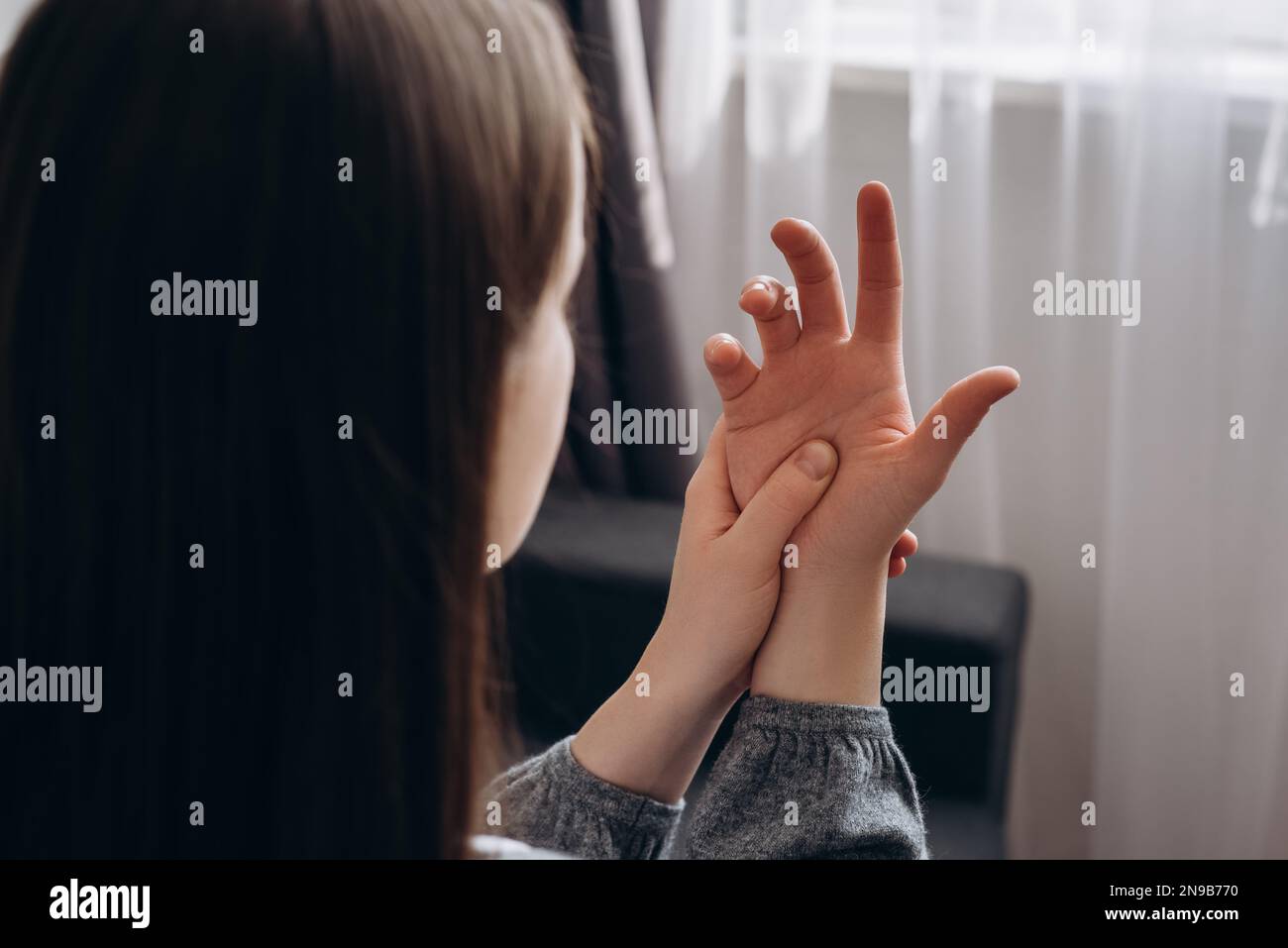 Seitenansicht einer jungen 20s mit Schmerzen in der Handfläche. Frau massiert schmerzhafte Hand