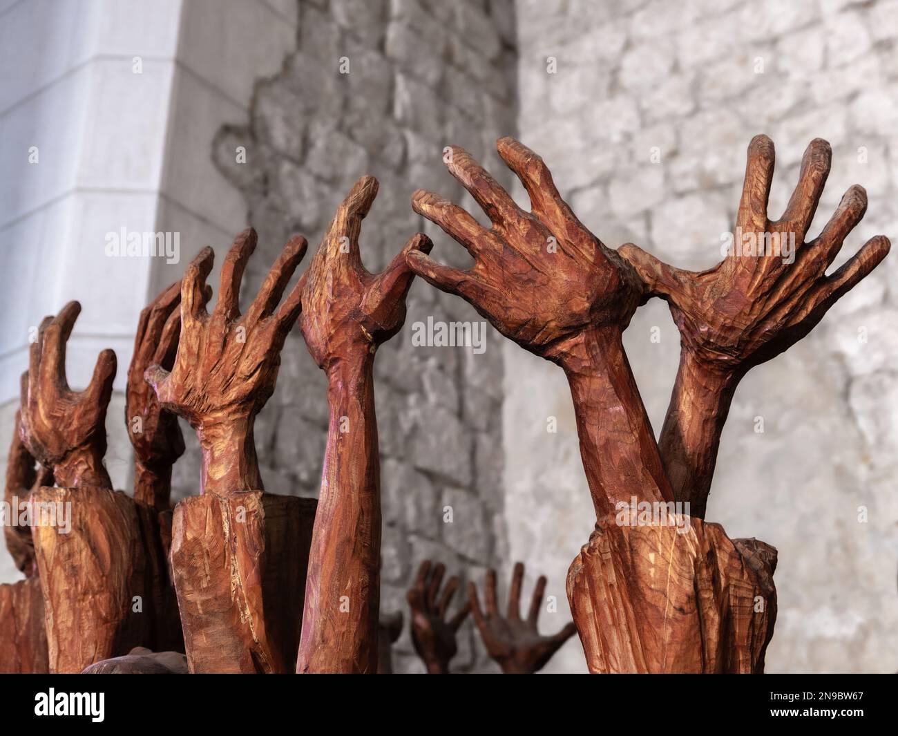 Venzone, Italien - 29. Dezember 2022: Ein Teil der Skulptur in der Kathedrale von Venzone mit erbauten Händen von Menschen, die um Gnade flehen. Stockfoto