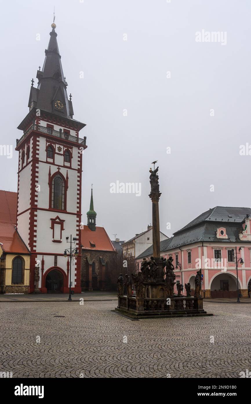 CHOMUTOV, TSCHECHISCHE REPUBLIK - 04. DEZEMBER 2022: Himmelskirche der Jungfrau Maria und der Stadtturm und die Säule der Heiligen Dreifaltigkeit. Stockfoto