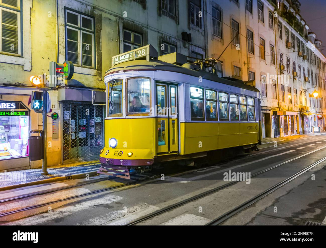 Lissabon, Portugal - 28. Dezember 2008: Traditionelle gelbe Straßenbahn in der Innenstadt von Lissabon bei Nacht am 29. Dezember 2008. Die Straßenbahnen werden von allen benutzt und halten auch Stockfoto