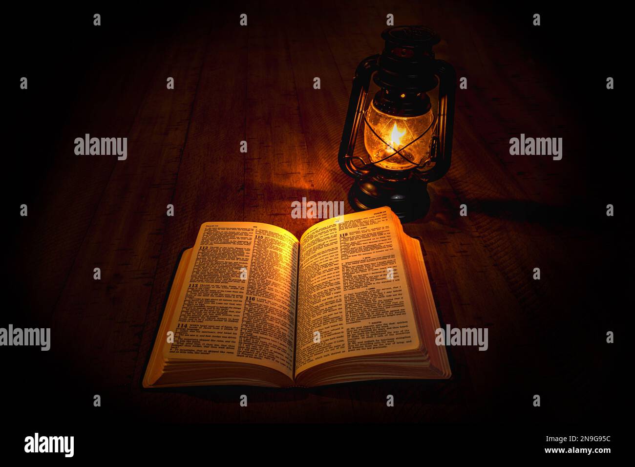 Ein offenes Buch und eine alte Lampe auf einem Tisch Stockfoto