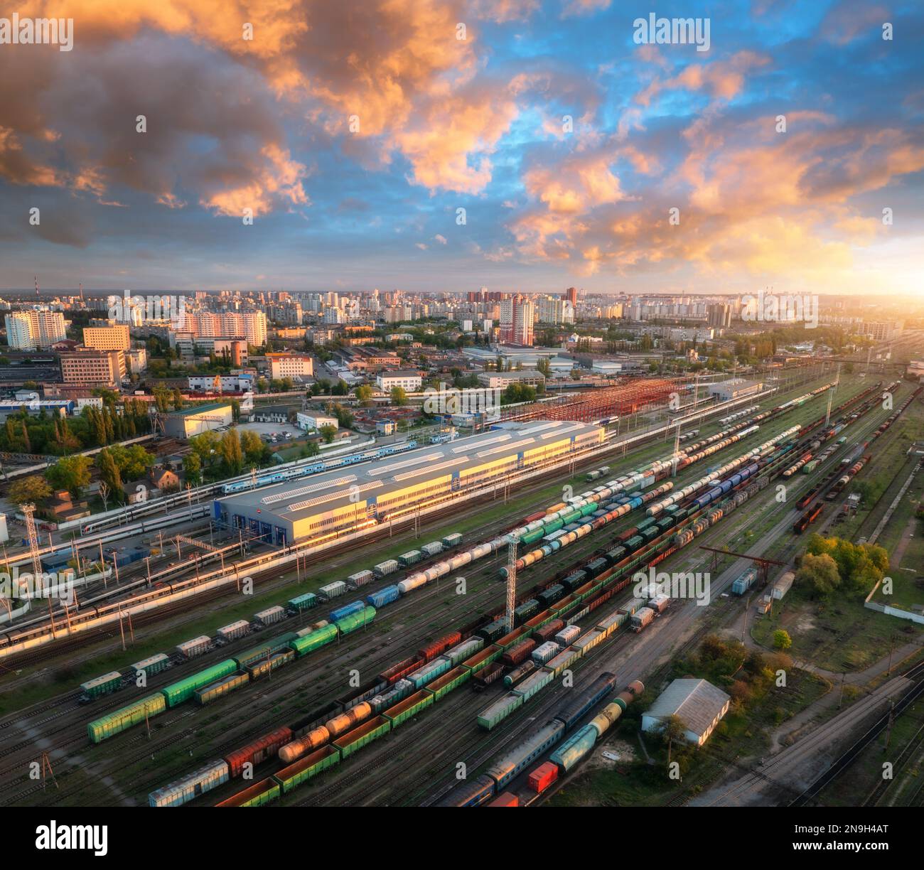 Luftaufnahme von Güterzügen bei Sonnenuntergang. Eisenbahnfrachtwagen Stockfoto