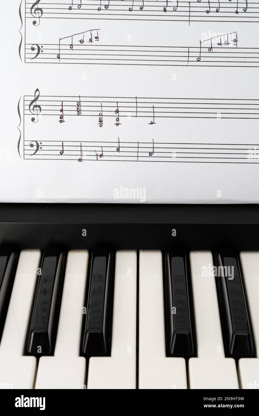 Musiktastatur und handgeschriebene Notenblätter in vertikaler Ausrichtung Stockfoto