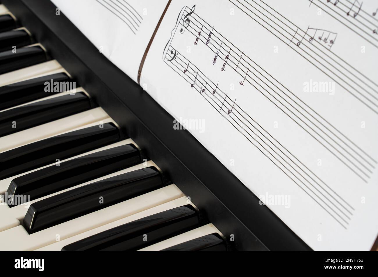 Musiktastatur und handgeschriebene Notenblätter Stockfoto