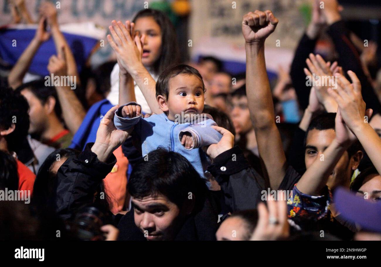 A child looks as people protest against Paraguay's recently sworn-in interim President Federico Franco outside a public TV station in Asuncion, Paraguay, Sunday, June 24, 2012. Paraguay's new government battled a wave of criticism on Sunday as several of the nation's closest allies condemned the recent dismissal of President Fernando Lugo by lawmakers, some calling it a congressional coup.(AP Photo/Jorge Saenz) Stockfoto