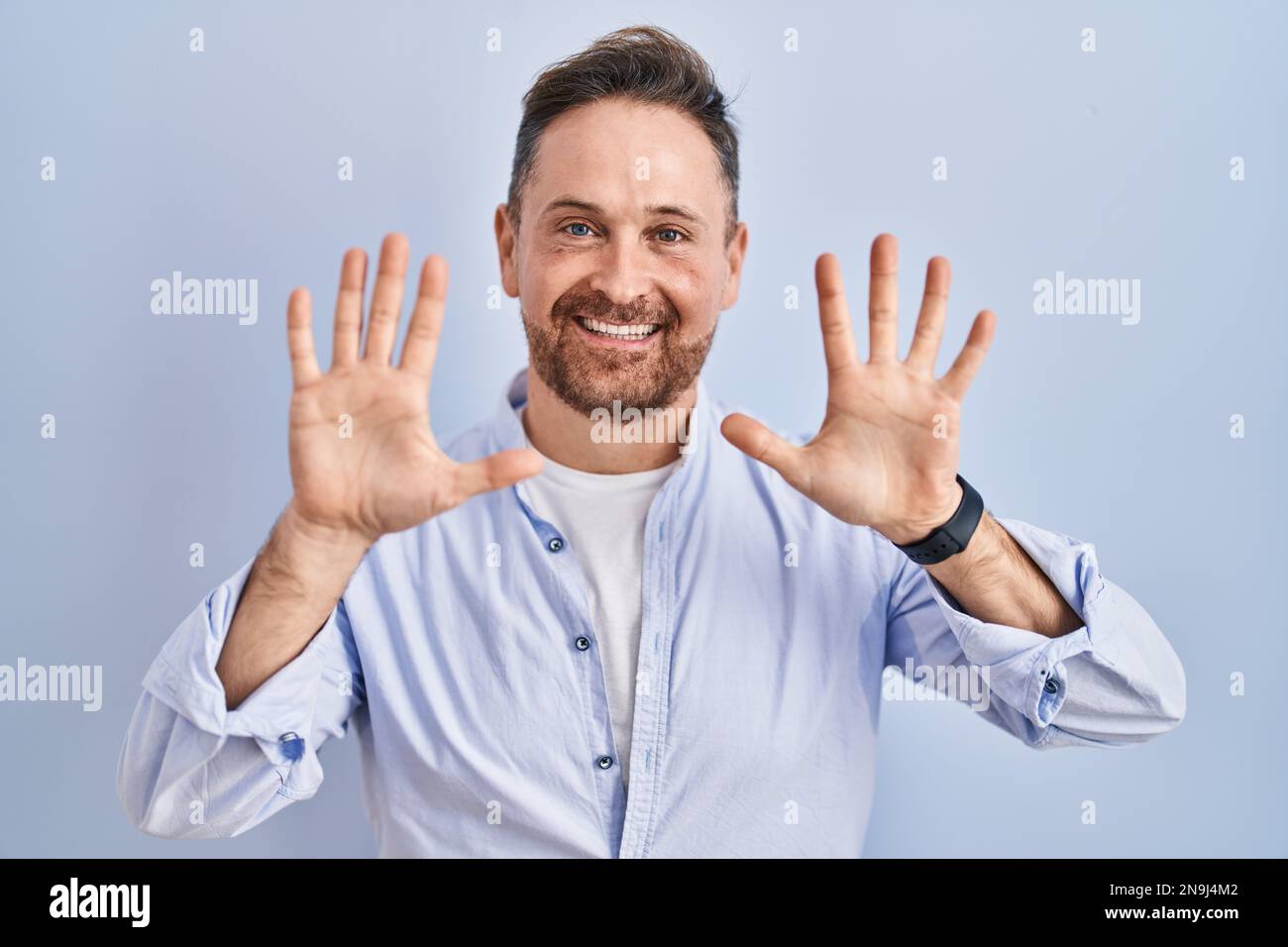 Ein weißer Mann mittleren Alters, der auf blauem Hintergrund steht und ...