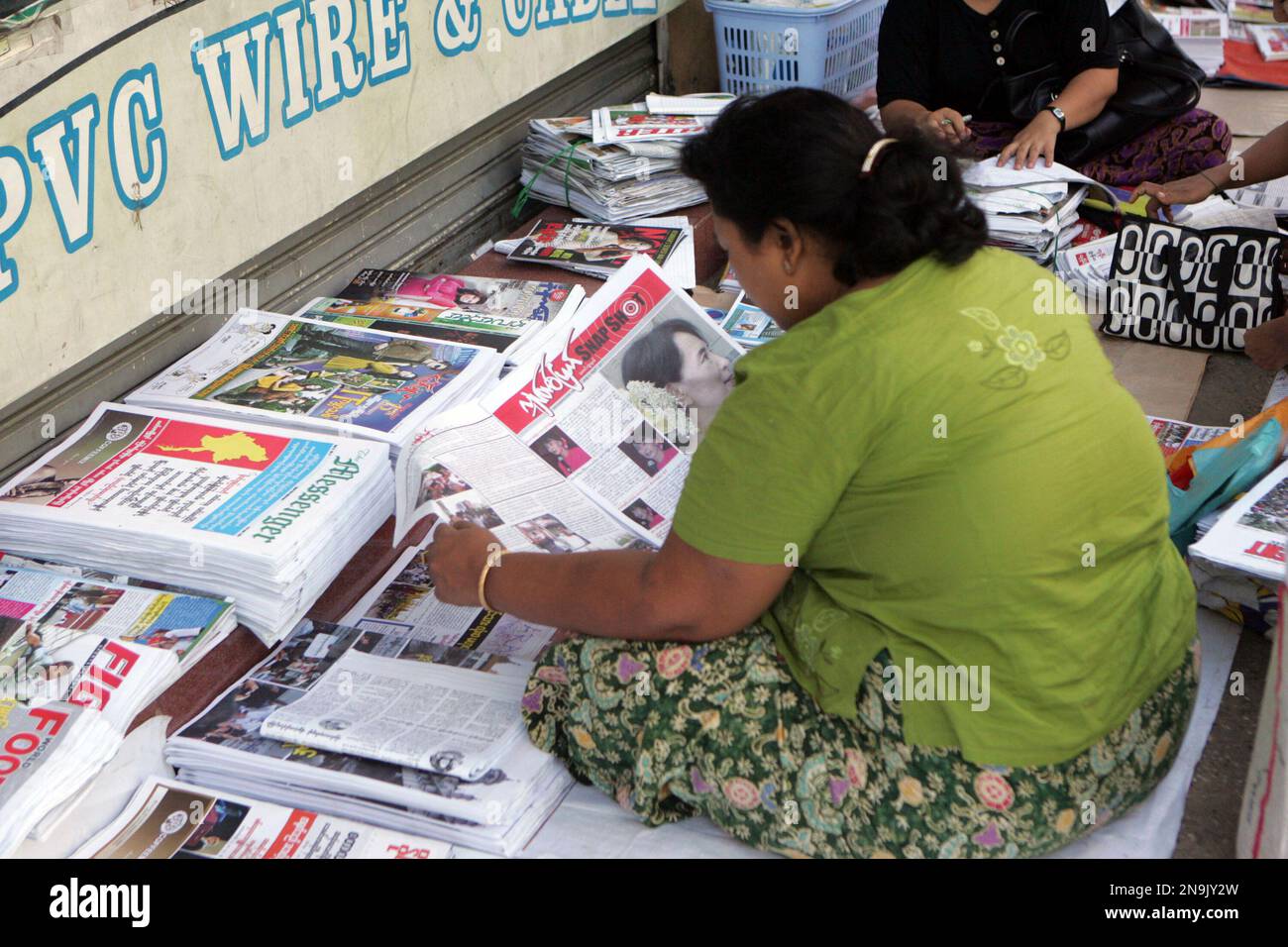 In This Sunday June 10 2012 Photo A Woman Reads A Weekly News Journal At A Roadside Newspaper