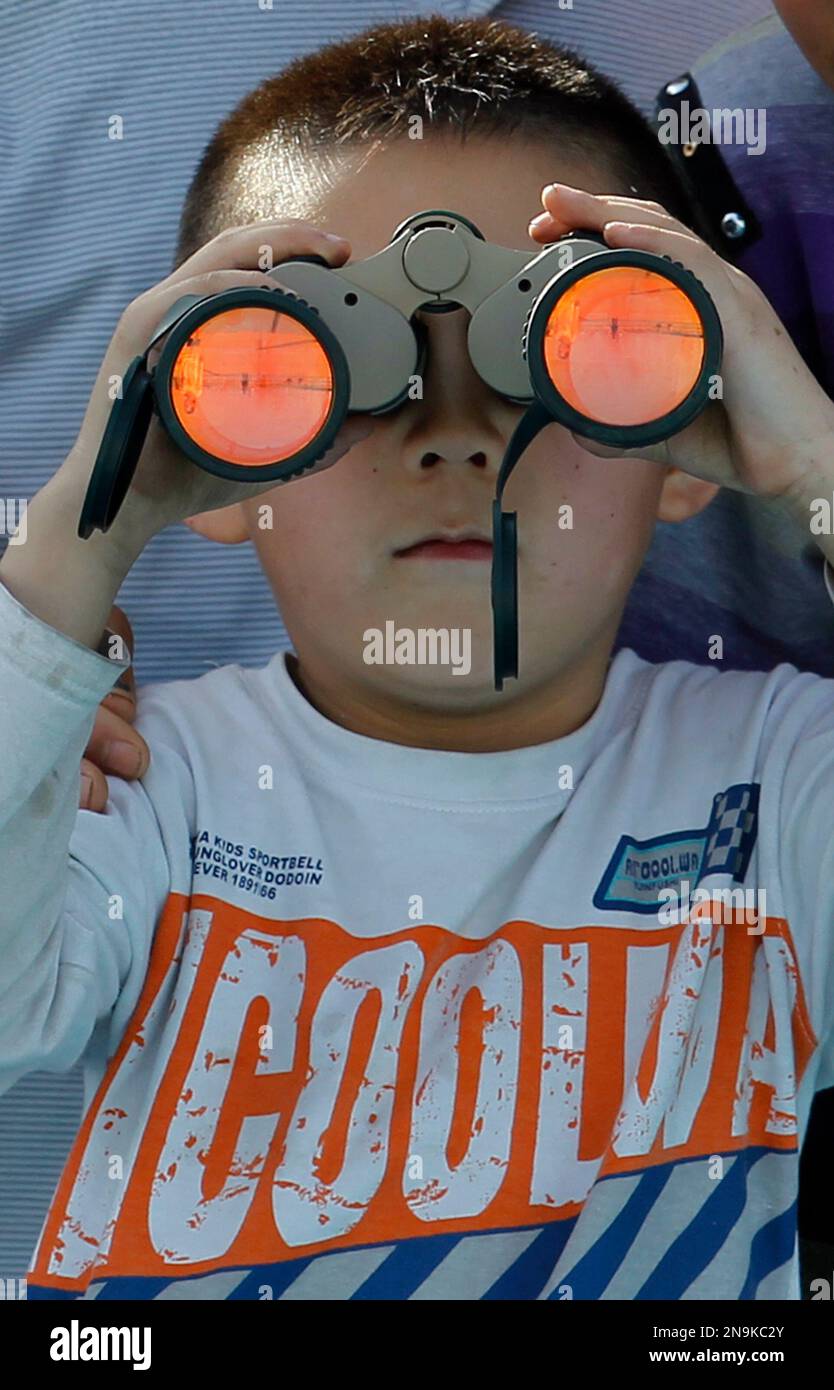 A child uses a pair of binoculars to view the Shenzhou 9 spacecraft rocket before it launches from the Jiuquan Satellite Launch Center in Jiuquan, China, Saturday, June 16, 2012. China sends its first woman and two other astronauts into space Saturday to work on a temporary space station for about a week, in a key step toward becoming only the third nation to set up a permanent base in orbit.(AP Photo/Ng Han Guan) Stockfoto