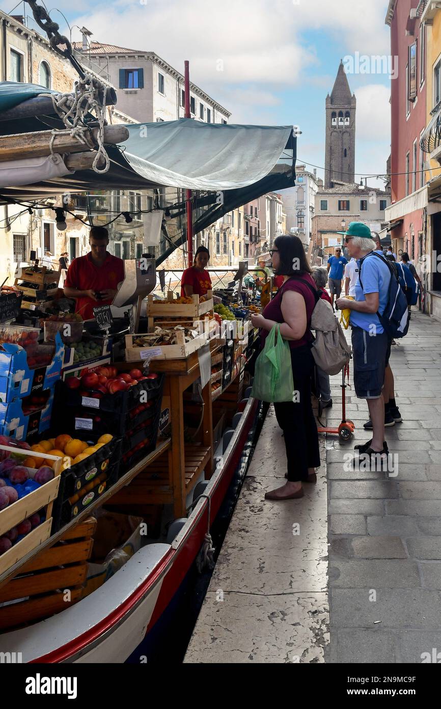 Leute, die im Sommer im Greengrocer Boot am Rio de San Barnaba Kanal in der Sestiere von Dorsoduro einkaufen, Venedig, Veneto, Italien Stockfoto