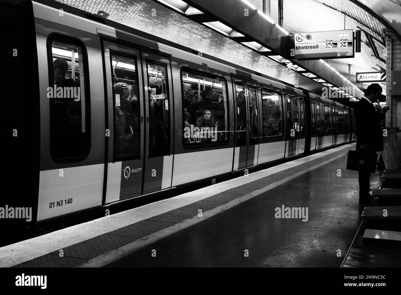 Eine Graustufenaufnahme eines Zuges voller Passagiere in Paris, Frankreich Stockfoto