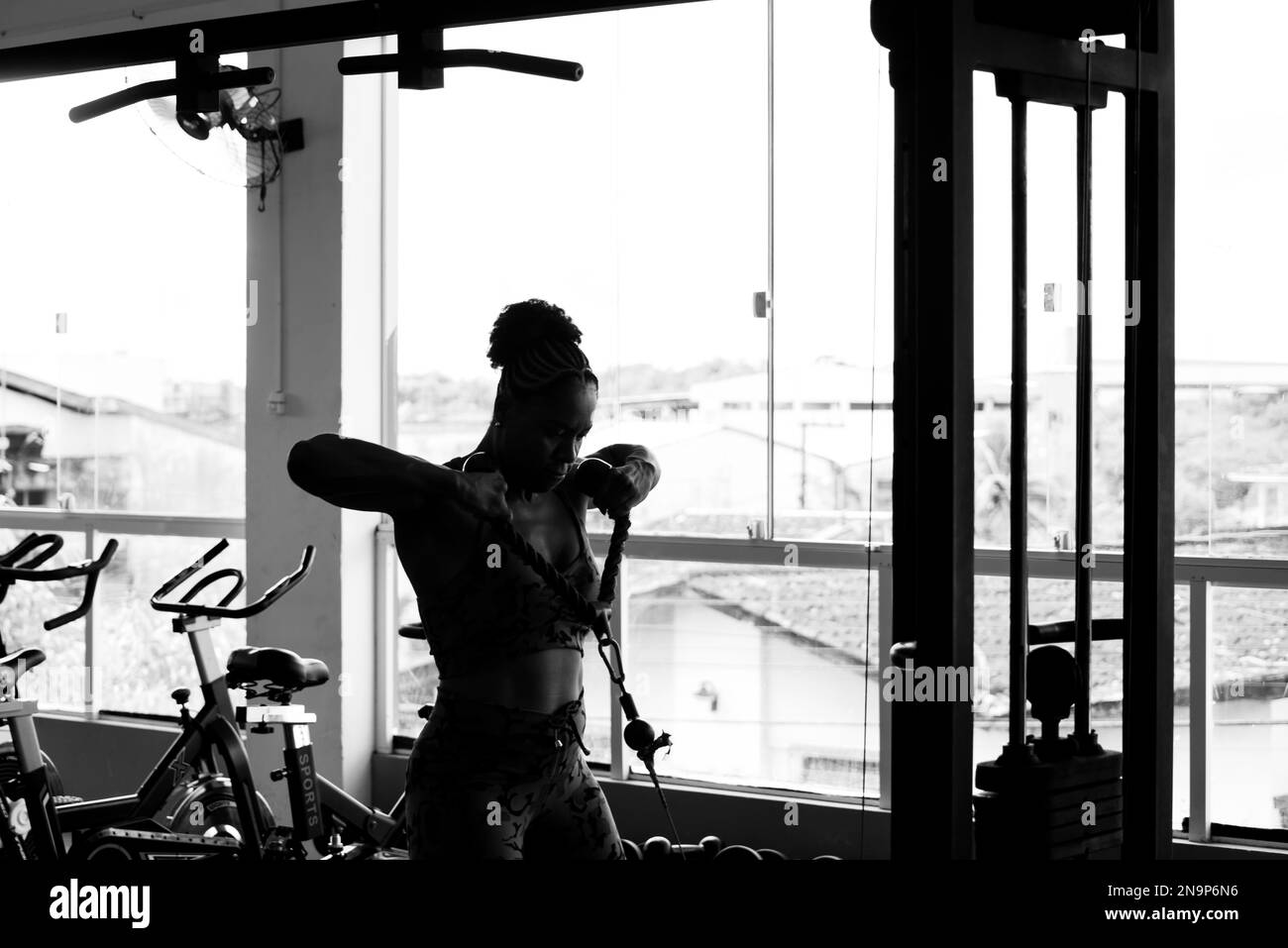 Eine muskuläre Frau, die Muskeln in den Armen und Schultern trainiert. Fitnessübungen im Studio. Stockfoto