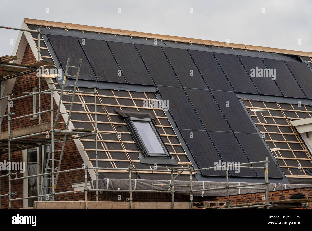 Neues Haus im Bau mit bereits installierten Solarpaneelen auf dem Dach Stockfoto