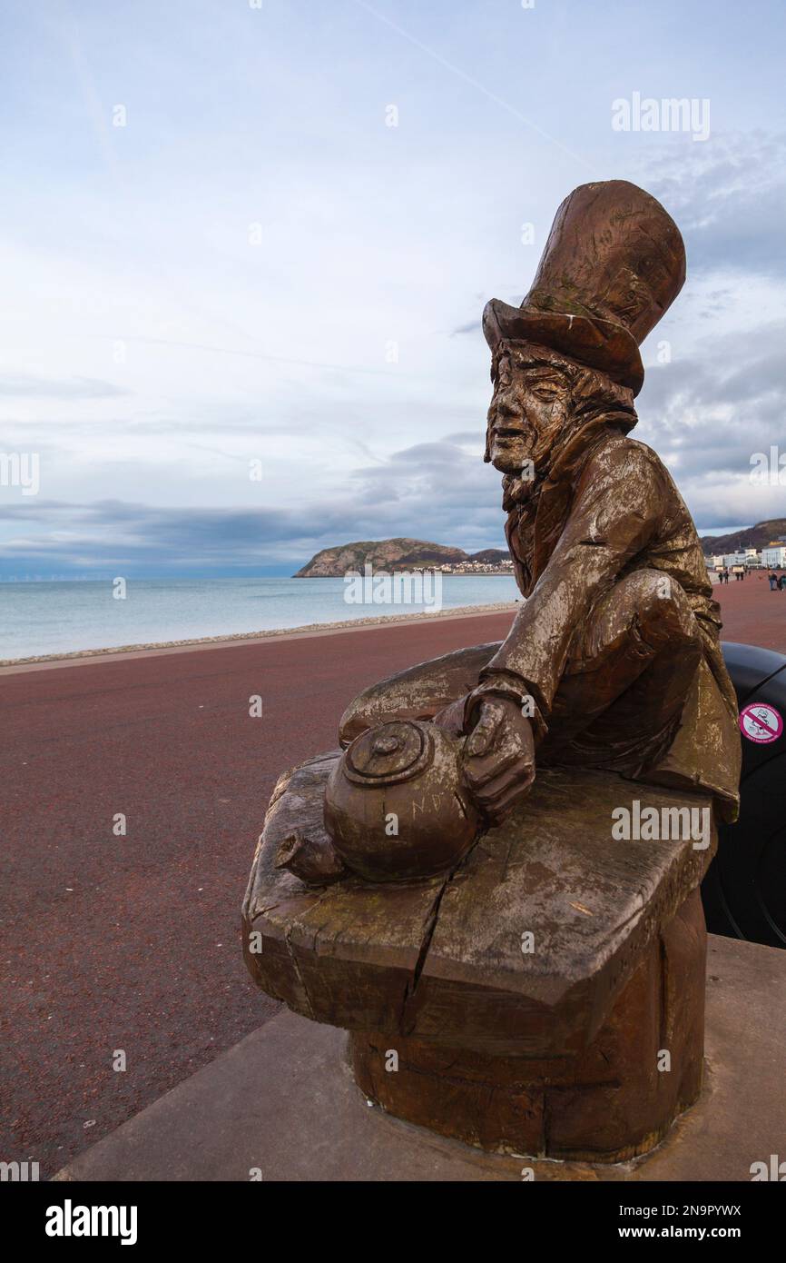 Die Küste von Llandudno, North Wales, UK mit der Holzstatue von Mad Hatter im Vordergrund und Little Orme im Hintergrund Stockfoto