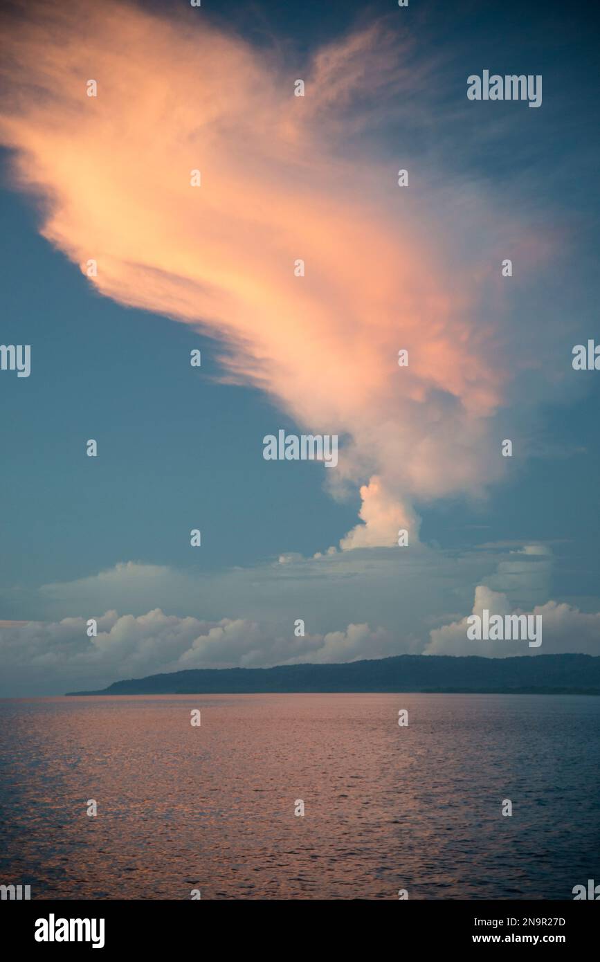 Sonnenaufgang über Golfo Dulce entlang der Küste Costa Ricas, mit sanftem rosa Licht, das auf dem ruhigen Wasser reflektiert wird; Costa Rica Stockfoto