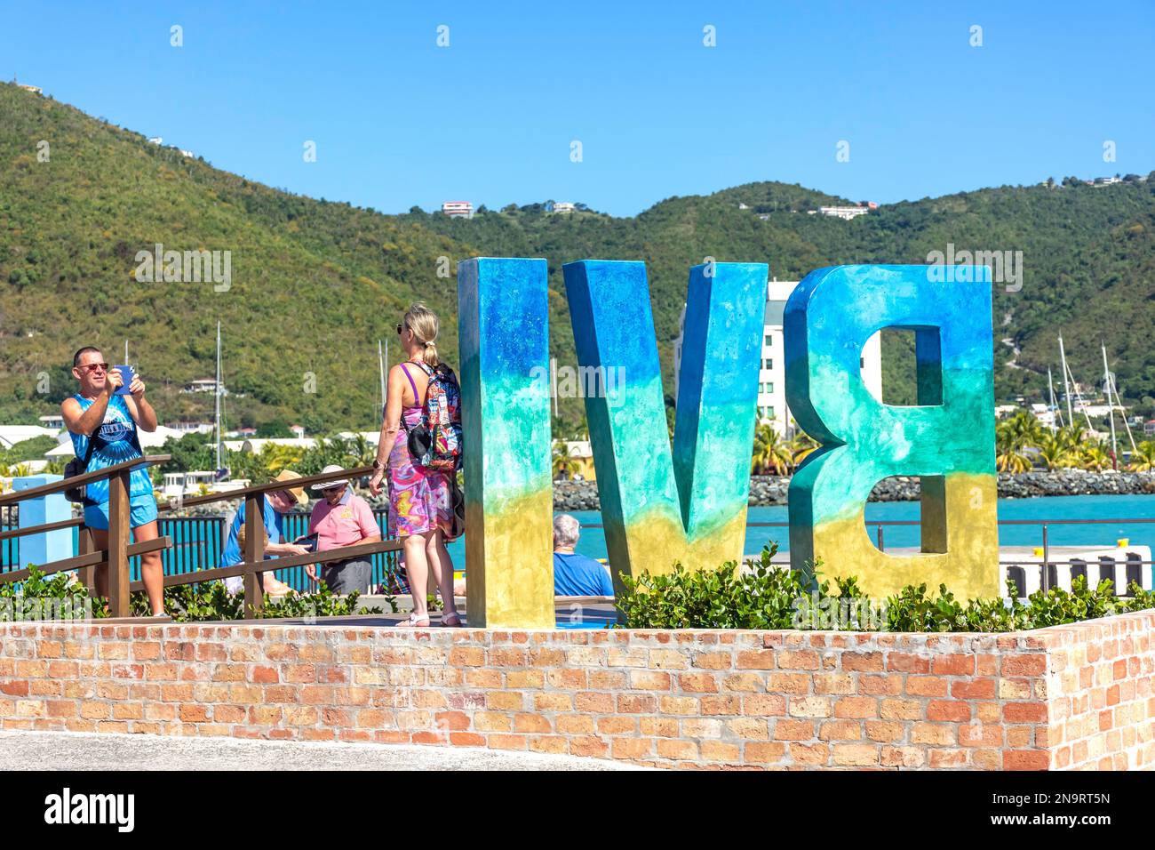 Ein Paar mit BVI-Schild (Britische Jungferninseln) am Tortola Pier Park, Road Town, Tortola, den Britischen Jungferninseln (BVI), den kleinen Antillen, der Karibik Stockfoto