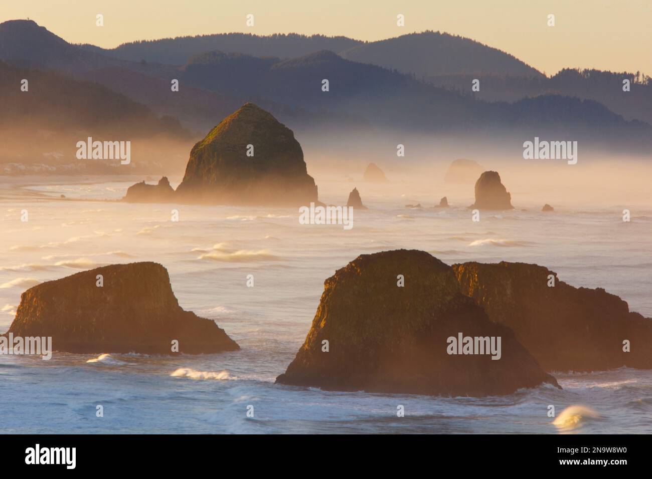 Sonnenaufgang und Morgennebel verleihen Cannon Beach und Haystack Rock im Ecola State Park, Oregon, USA, Schönheit Stockfoto