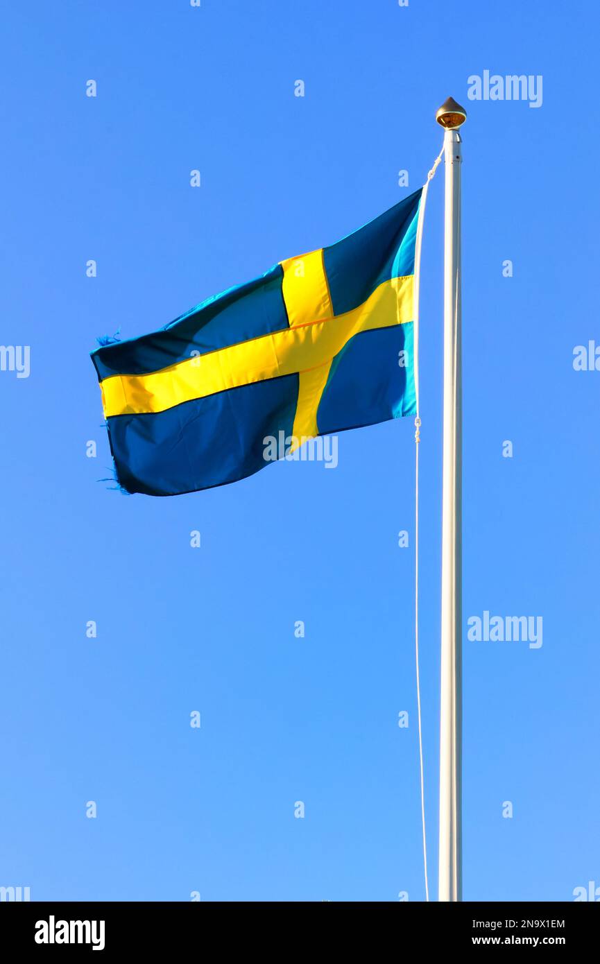 Fahnenstange mit schwedischer Nationalflagge und blauem Himmel im Hintergrund Stockfoto