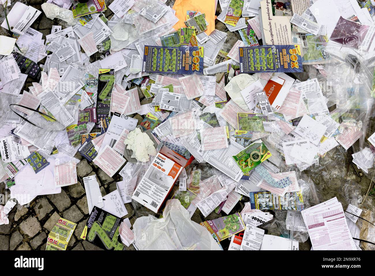 Hunderte von Lotteriekarten und Glückskratzkarten, neben anderen Papieren, die auf der Straße, auf dem Bürgersteig und nicht im Müll weggeworfen wurden Stockfoto