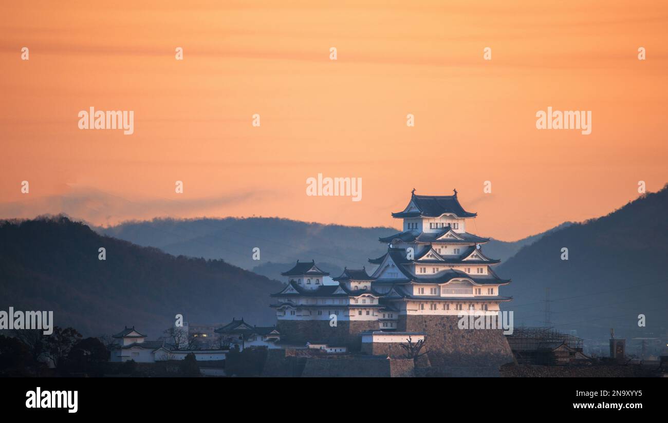 Orangefarbener Himmel über dem historischen japanischen Schloss und Himeji-Landschaft bei Sonnenaufgang Stockfoto